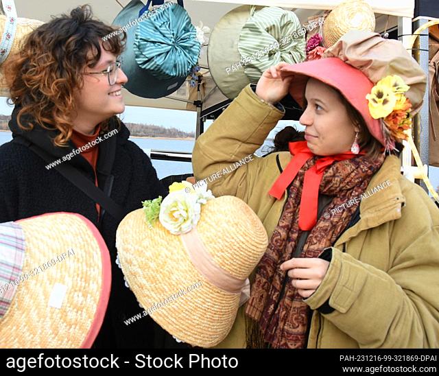 16 December 2023, Saxony, Schkeuditz: Ellen and Lisa Schuten try on historical costumes from the Biedermeier period at the Victorian Christmas market at...