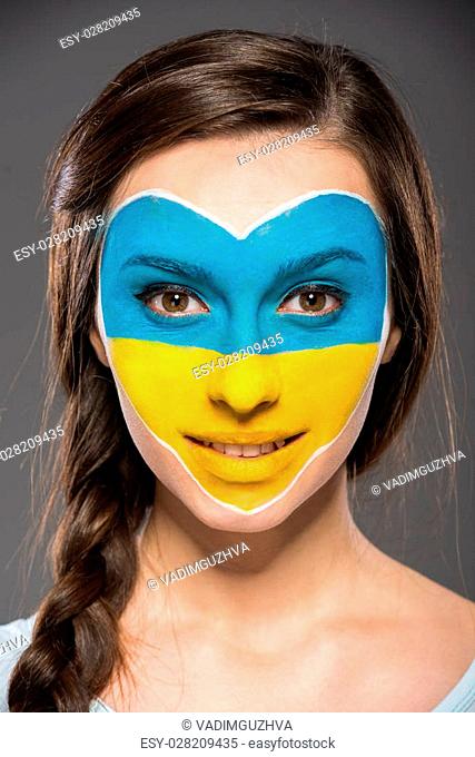 Flag of Ukraine painted on the face of the young beautiful woman