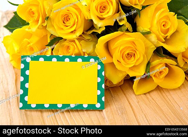 Mothers day greeting card or photo frame and yellow rose over wooden table
