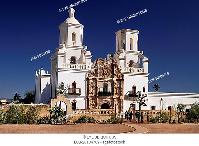 Mission Church of San Xavier del Bac. Exterior facade with visitors at entrance