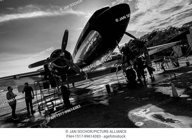 Colombian mechanics perform a full routine maintenance check of a Douglas DC-3 aircraft outside the hangar at the airport of Villavicencio, Colombia