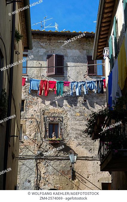 Colorful laundry is hanging outside a house to dry in Pienza, Val d'Orcia, Tuscany, Italy