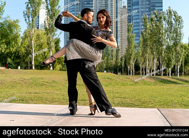 Male and female Tango dancers doing rehearsal in public park