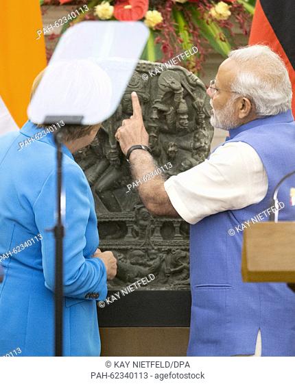German chancellor Angela Merkel symbolicly hands over the statue of Hindu goddess Durga to Indian Prime Minister Narendra Modi at the Hyderabad House after the...