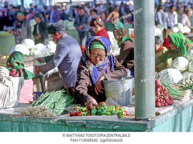 Old Uzbekistan sorts its offer of peppers and other vegetables at the market in Khiva, analogue and undated record of October 1992