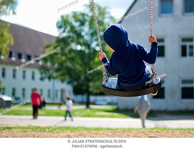 A refugee boy sits on a swing on a playground in the state accomodation office in Brunswick, Germany, 27 August 2014. The accomodation of the growing number of...
