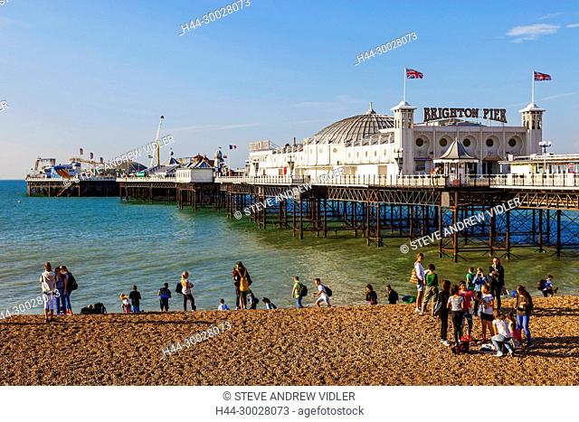 England, East Sussex, Brighton, Group of Foreign Students on Beach and Brighton Pier
