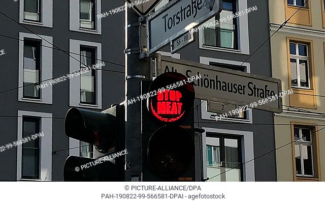 22 August 2019, Berlin: ""stop meat"" is written on the red light of a traffic light at Schönhauser Straße/Torstraße. There