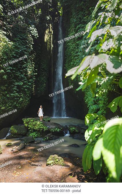 Woman by waterfall in Bali, Indonesia