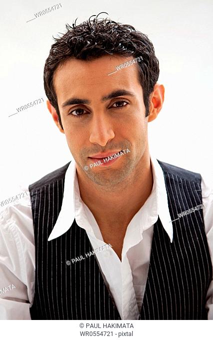 Handsome male wearing a white shirt and black pinstripe vest, isolated