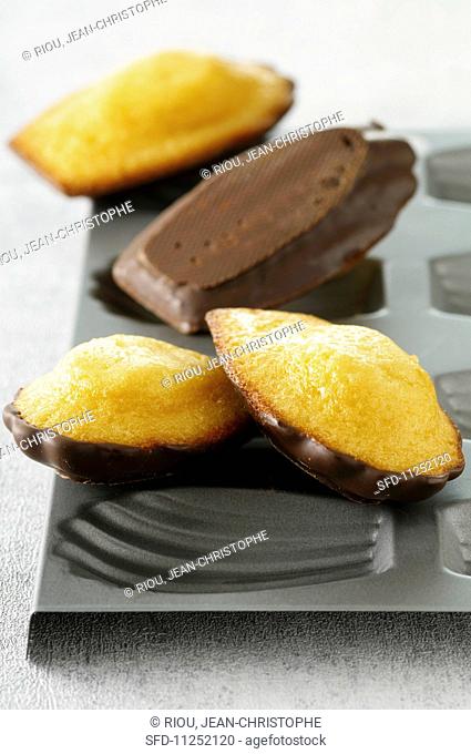 Madeleines with chocolate glaze on top of the baking tin