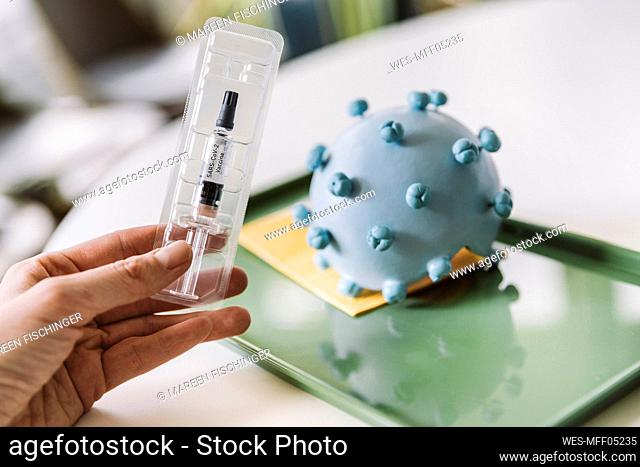 Hand holding Corona virus vaccine dose