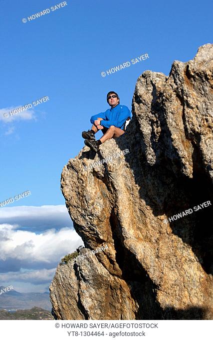 Man sitting on a rock ledge