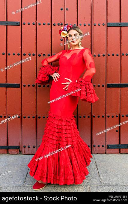 Female flamenco dancer with hands on hip standing on footpath