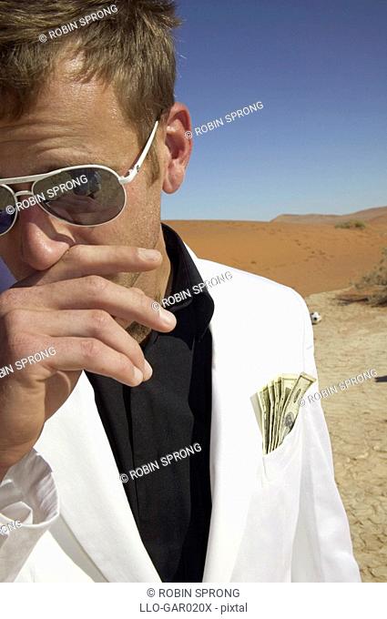 Man in a White Suit with Money in his Pocket, in the Desert  Namibia