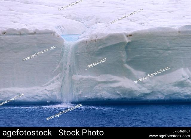 Meltwater flowing from the ice wall of the melting Brasvellbreen Glacier into the Arctic Ocean, Austfonna, Nordaustlandet, Svalbard, Norway, Europe