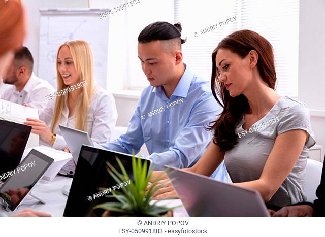 Multi Ethnic Business People Working With Digital Tablet And Laptop At Table In Office