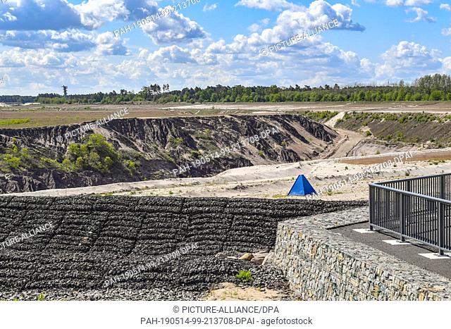 13 May 2019, Brandenburg, Cottbus: Panoramic view over the former opencast lignite mine Cottbus-Nord. The blue measuring point indicates the future waterline