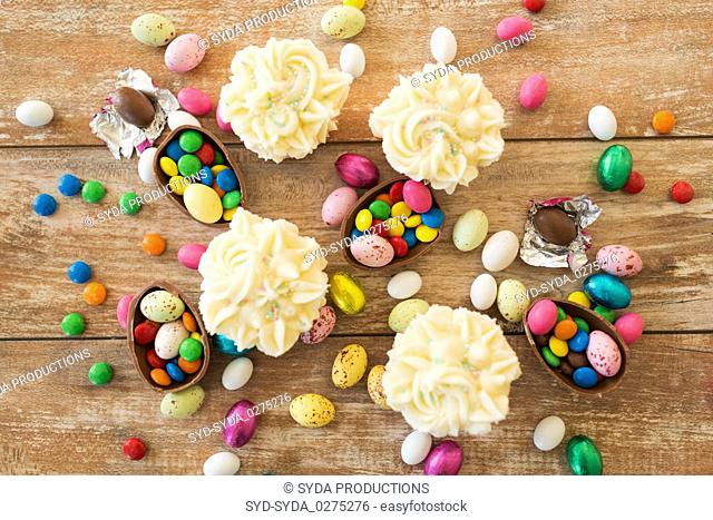 cupcakes with chocolate eggs and candies on table