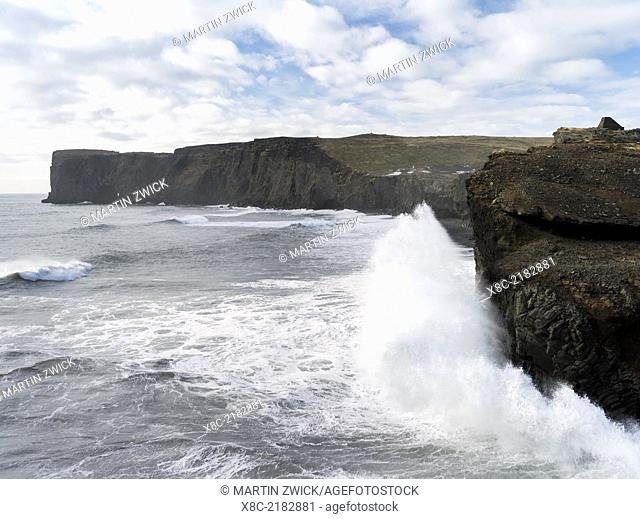 Coast of the North Atlantic near Vik y Myrdal during a winter storm, view towards the stacks and sea arch at cape Dyrholaey