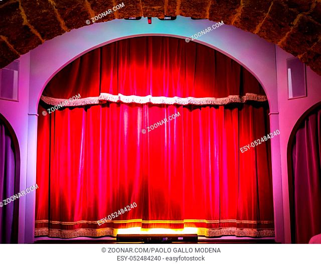 A red curtain in an old and very small Italian theatre