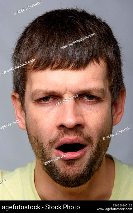 Closeup portrait of a tired yawning man of European appearance
