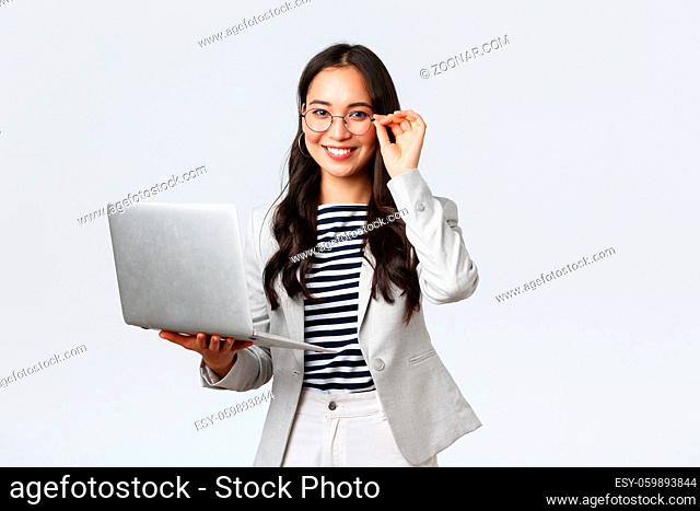 Business, finance and employment, female successful entrepreneurs concept. Confident smiling asian businesswoman, office worker in white suit and glasses using...