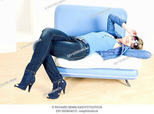 woman wearing blue clothes lying on sofa