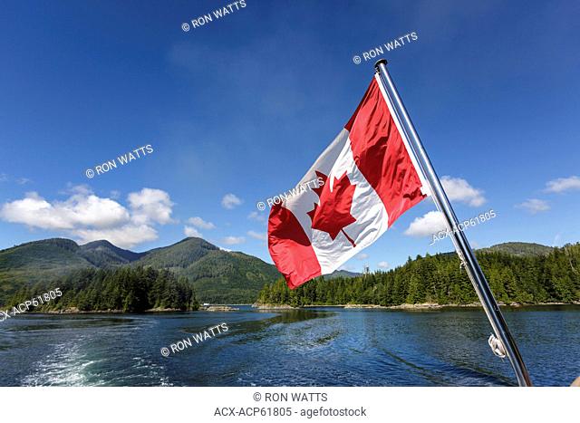 The Canadian Flag flies from the stern of the Uchuck 111 as it traverses Esperanza Inlet, British Columbia, Canada