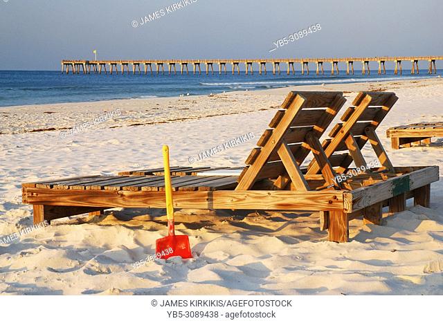 Two lounge chairs and a shovel await the next relaxer on the beach in Pensacola, Florida