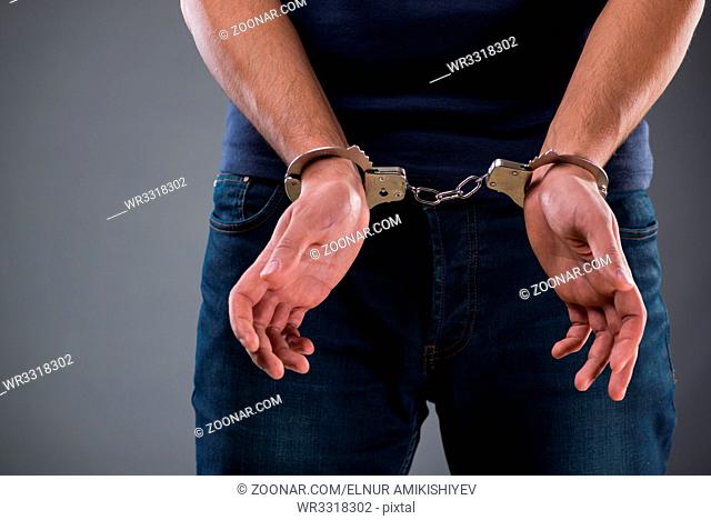 Man with his hands handcuffed in criminal concept