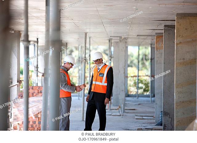 Construction workers shaking hands on construction site
