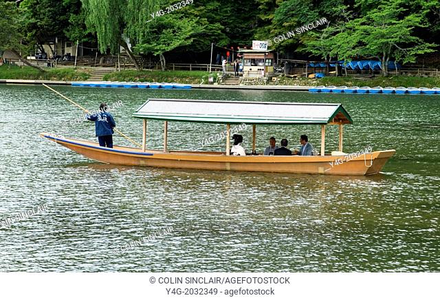 Japan, Kyoto, Arashiyama, Banks of Hozu River, Geisha on pleasure boat for a punt up and down the Hozu River with male clients, Boats in background