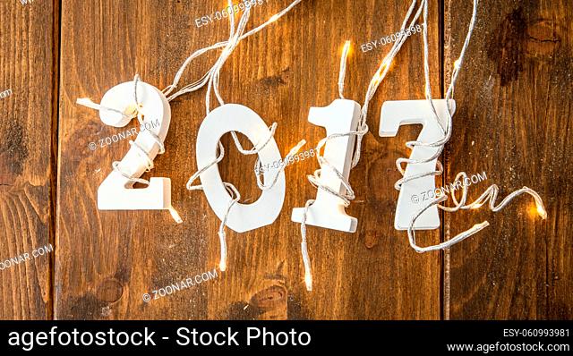 2017 mit Lichterkette auf rustikalem Hintergrund aus Holz