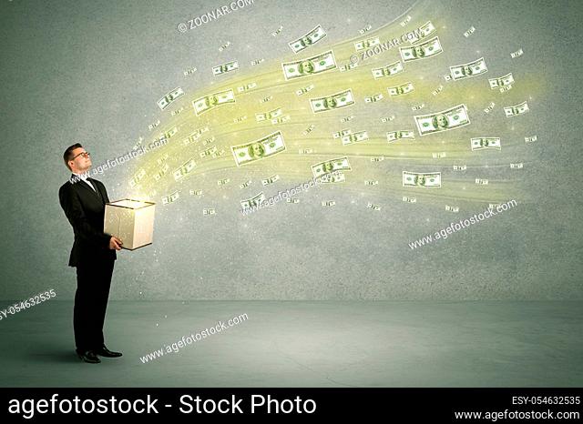 Successful young sales person making a lot of money concept illustrated with euro dollar bills flying out of a box held in his hand