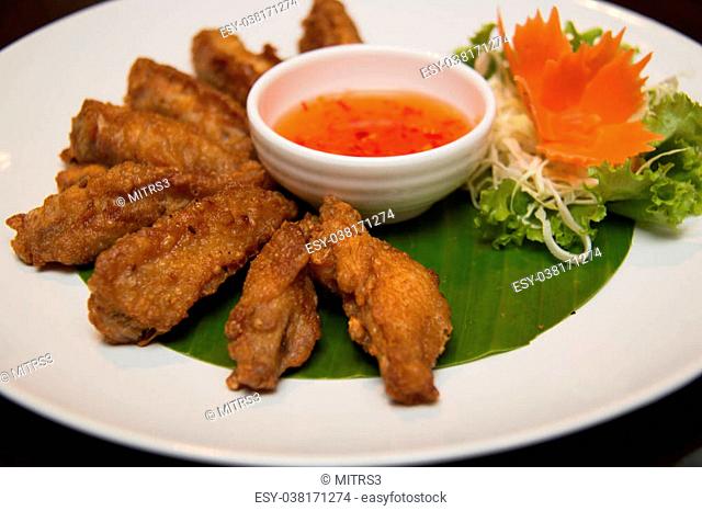 A Deep fried spicy chicken wing with chili sauce
