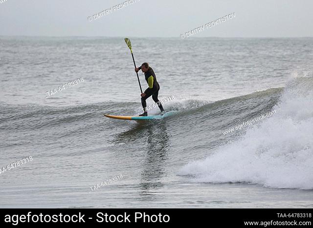 RUSSIA, SOCHI - NOVEMBER 13, 2023: A man goes standup paddleboarding during a storm on the Black Sea, in the Khosta neighbourhood