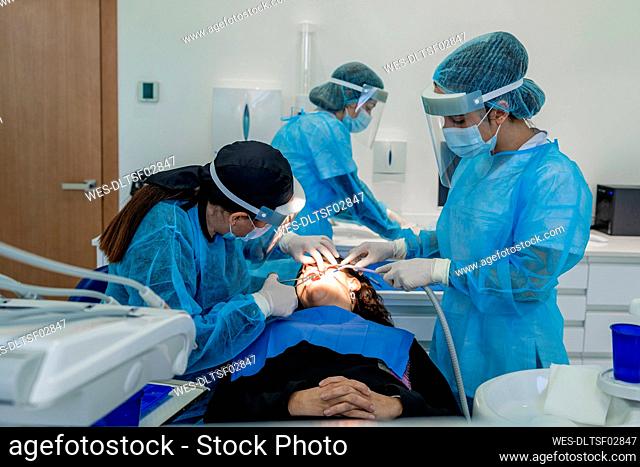 Surgeon with nurses doing surgery of patient in operating room at hospital