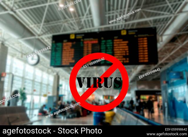 Wuhan coronavirus pandemic concept with forbidden sign with the word virus superimposed against unidentifiable purposely left out of focus airport terminal