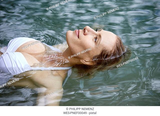 Portrait of relaxed woman floating on water
