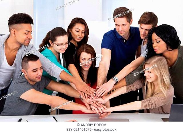 University Students Stacking Hands At Desk