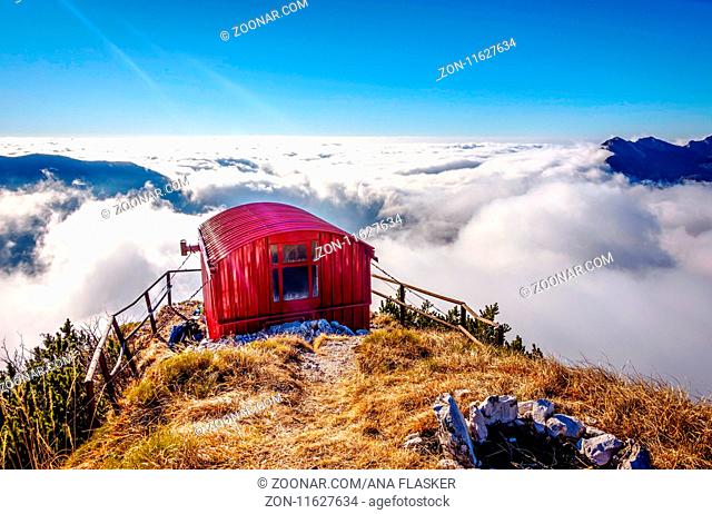 Bivacco Dino bivouac with the sea of clouds under. The Alps, Italy