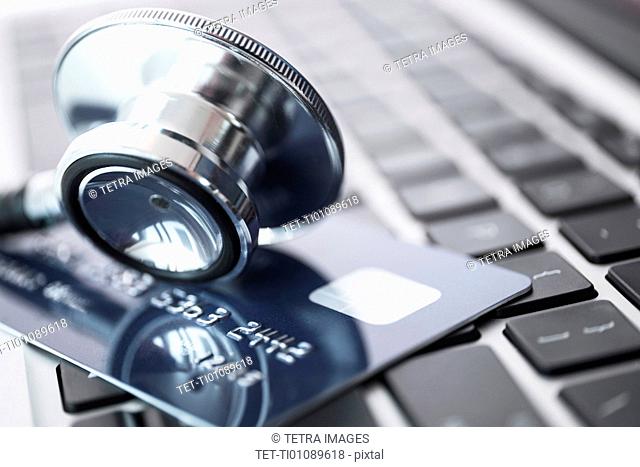 Stethoscope and credit card lying on laptop