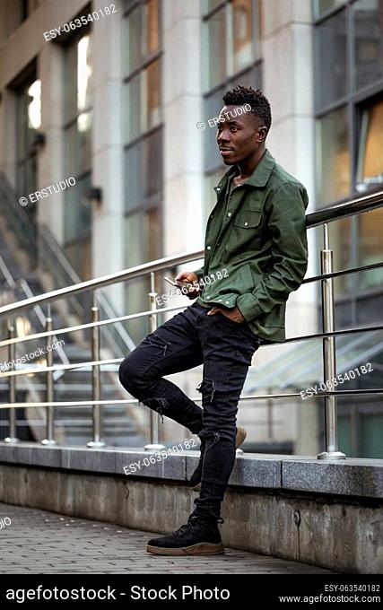 african-american man in stylish jacket on city street in the evening