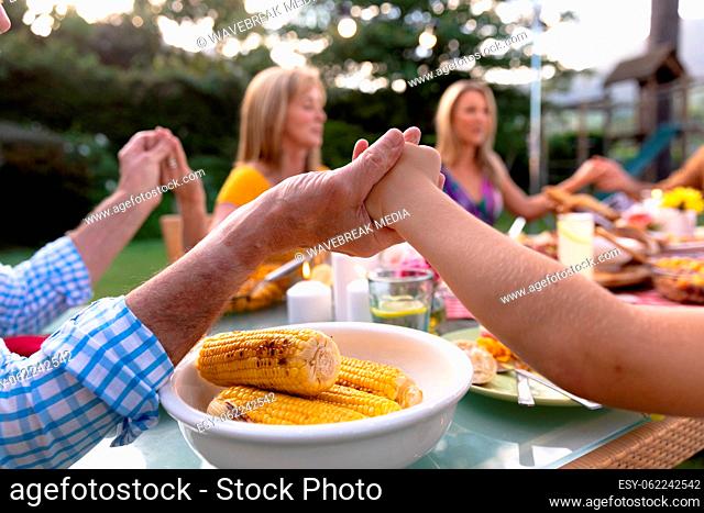 Caucasian family saying grace together before eating