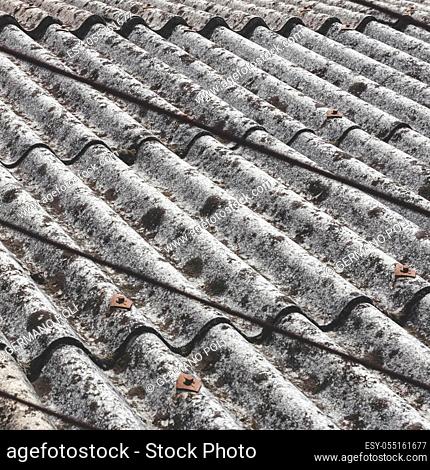 Old and dangerous asbestos roof, one of the most dangerous materials in the construction industry. Eternit roof covering of a scruffy old and moldy