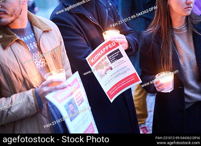 12 October 2023, Berlin: People hold sheets of paper with missing persons reports of people who fell victim to Hamas attack in Israel
