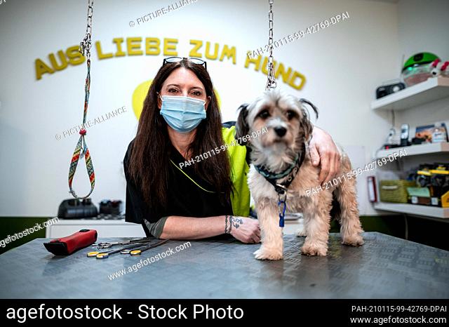 15 January 2021, North Rhine-Westphalia, Emsdetten: Dog groomer Elisa Kloppenburg from Emsdetten stands with a dog in her ""hair salon""