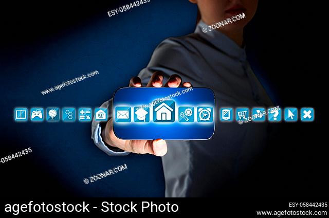 Hand holding smartphone and apps icons flying in air