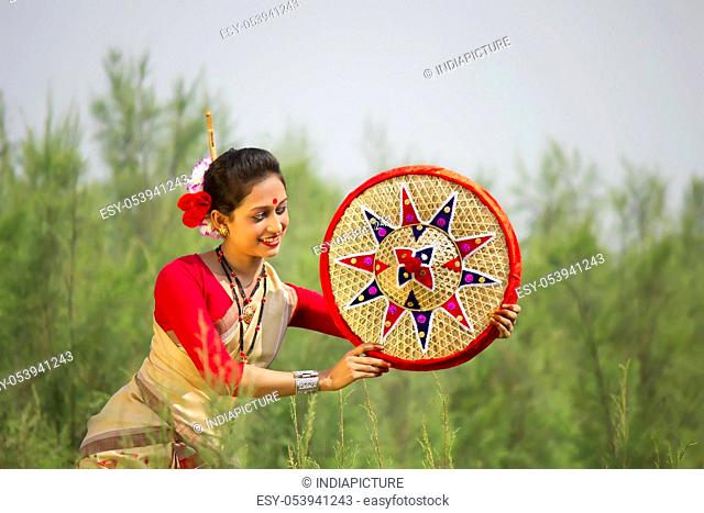 Bihu dancer holding a jaapi
